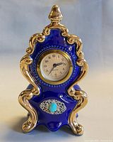 Front view of cobalt blue and gold porcelain Mercedes mantel clock