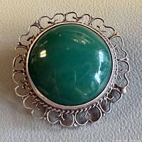 Front view showing green onyx cabochon and filigree silver border