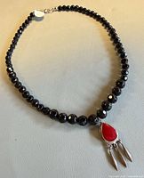 Full view of necklace laid flat showing bead strand and pendant