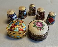 Group view of five thimbles and two pill boxes