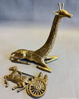 Both brass pieces together: giraffe figurine and horse-cart plaque