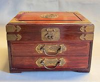 Front view showing two drawers, brass hardware and wood finish