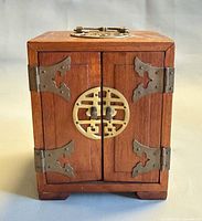 front view showing doors, brass medallion latch, hinges, feet