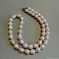 Full view of the pearl necklace coiled to show overall length and clasp