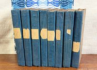All eight volumes standing; blue cloth spines with labels