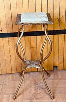Full view of brass plant stand showing overall form and legs