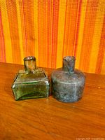 Front view of both ink bottles showing shapes and shear tops