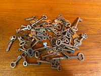 Pile of assorted antique keys on wood surface