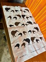 Full view of linen wall hanging showing kiwi motif and bottom text