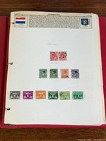 Album page with Netherlands header, flag, coat of arms, and 12 mounted stamps
