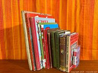 Group shot of all books standing upright with cassette at end