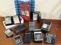 Group shot of all eleven calculators and boxed item