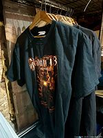 Row of black biker graphic shirts and hoodie hanging on wooden hangers