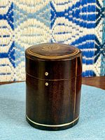Cylindrical leather box front view showing pins and metal band