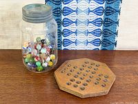 Jar of marbles beside wooden board