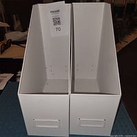 Front view of two identical white metal magazine file holders showing label plates