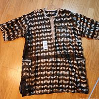 Full view of kaftan laid flat showing pattern and pockets