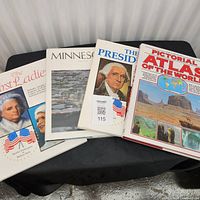 Four large coffee table books stacked and fanned showing covers