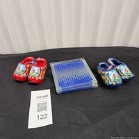 Overview of two pairs of wooden clogs and stack of glass coasters