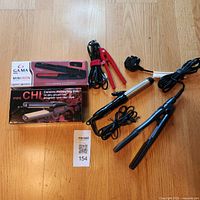 Full lot showing two boxed mini irons, three loose irons and cords