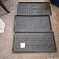 Three identical trays laid out on carpet showing overall appearance