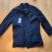 Full view of coat laid flat showing overall style, color and pockets.