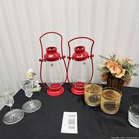 full lot overview showing two red lanterns, glassware, figurine and flower arrangement