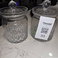 Two Rogaska Gallia crystal biscuit jars with lids on countertop