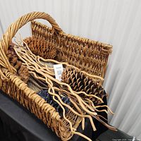 Top view of wicker basket showing pinecones, twigs and botanicals