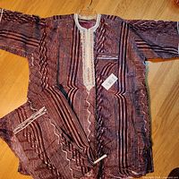 Full view of tunic and trousers laid flat showing overall pattern and color