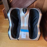 Top view of silver and black electric Shiatsu leg massager showing dual foot wells