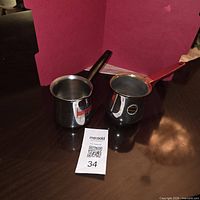 Two stainless steel Turkish coffee pots on table