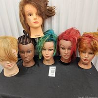 Six mannequin heads in a row showing various hair colours and styles