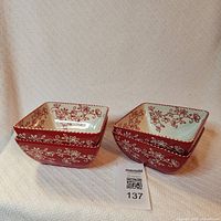 Two stacks of red Floral Lace square bowls