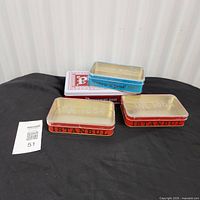 All four tins grouped on black surface