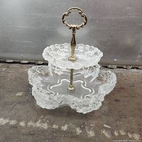 Full view of two-tier pressed glass tray showing floral pattern and handle