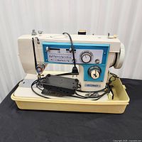 Front view of Dressmaker sewing machine on base with foot pedal