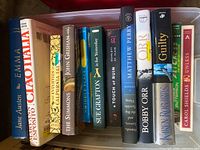 Spines of all twelve books lined in plastic tote