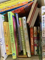 Box showing spines of assorted children’s, puzzle and reference books