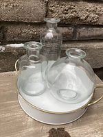 Three glass vases attached to white tray