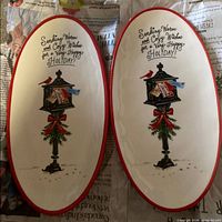 Two identical oval ceramic holiday trays side by side