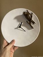 Front view showing clock face and bird ornament
