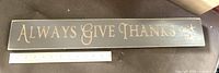 Front view of wooden sign showing full text and ruler for scale