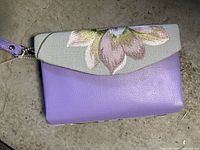 Front view showing floral flap, purple body, wrist strap