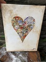 Full view of canvas showing heart collage design on textured background