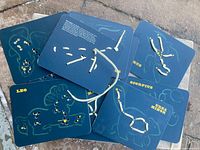 Stack of navy constellation lacing cards showing Leo, Scorpius, Ursa Minor, Ursa Major and white cord