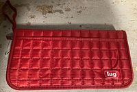 Front view of red quilted Lug travel wallet showing exterior and logo