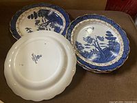 Fronts and one back of blue willow plates showing pattern and backstamp
