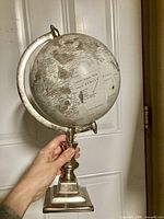 Full view of silver pedestal globe