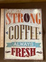 Full view of tin coffee sign with ruler for scale